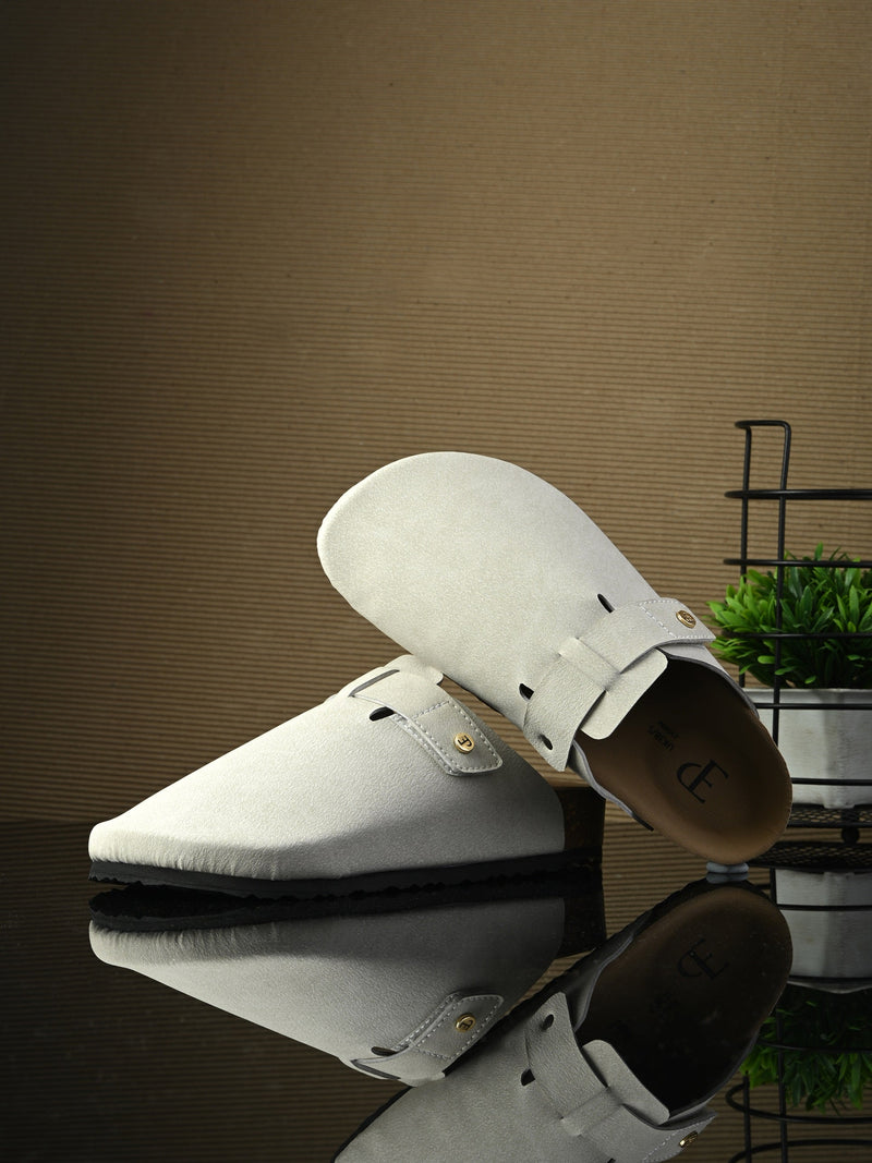 Nude suede slip-on clog with a black rubber sole and adjustable strap.