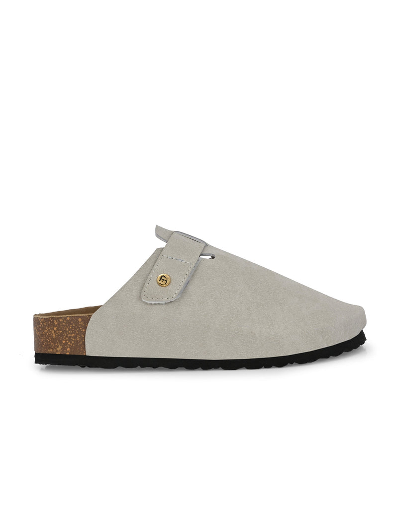 Nude suede slip-on clog with a black rubber sole and adjustable strap.