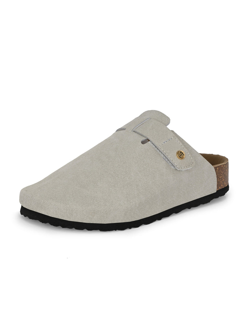 Nude suede slip-on clog with a black rubber sole and adjustable strap.