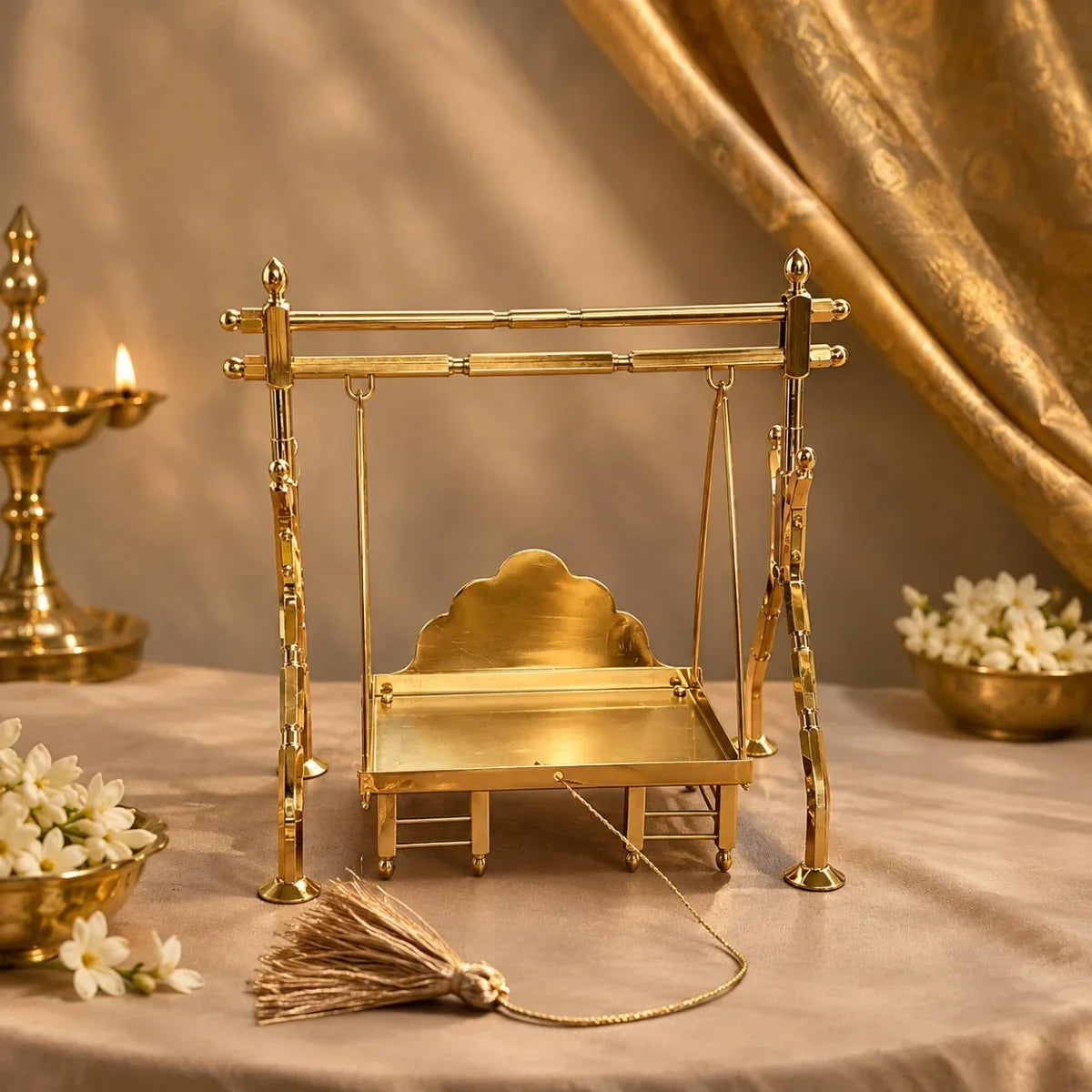 Brass jhula medium swing for Krishna idol with diya and jasmine flowers. ZIshta Janmashtami Pooja Essentials.