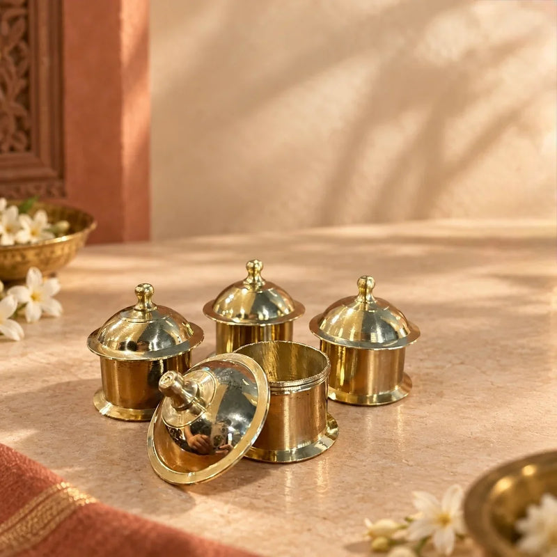 Brass Minar Kumkum Dibbi Set of 4, tower-shaped boxes with one lid open. Zishta Navratri Return Gifts.