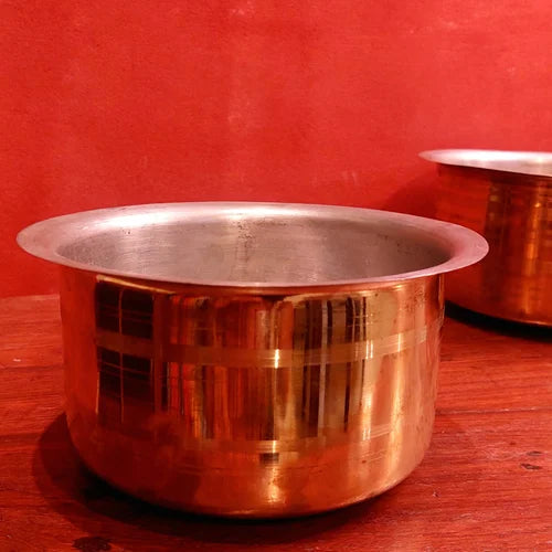 Brass Tope on a red surface with a red background-Zishta Traditional Cookware