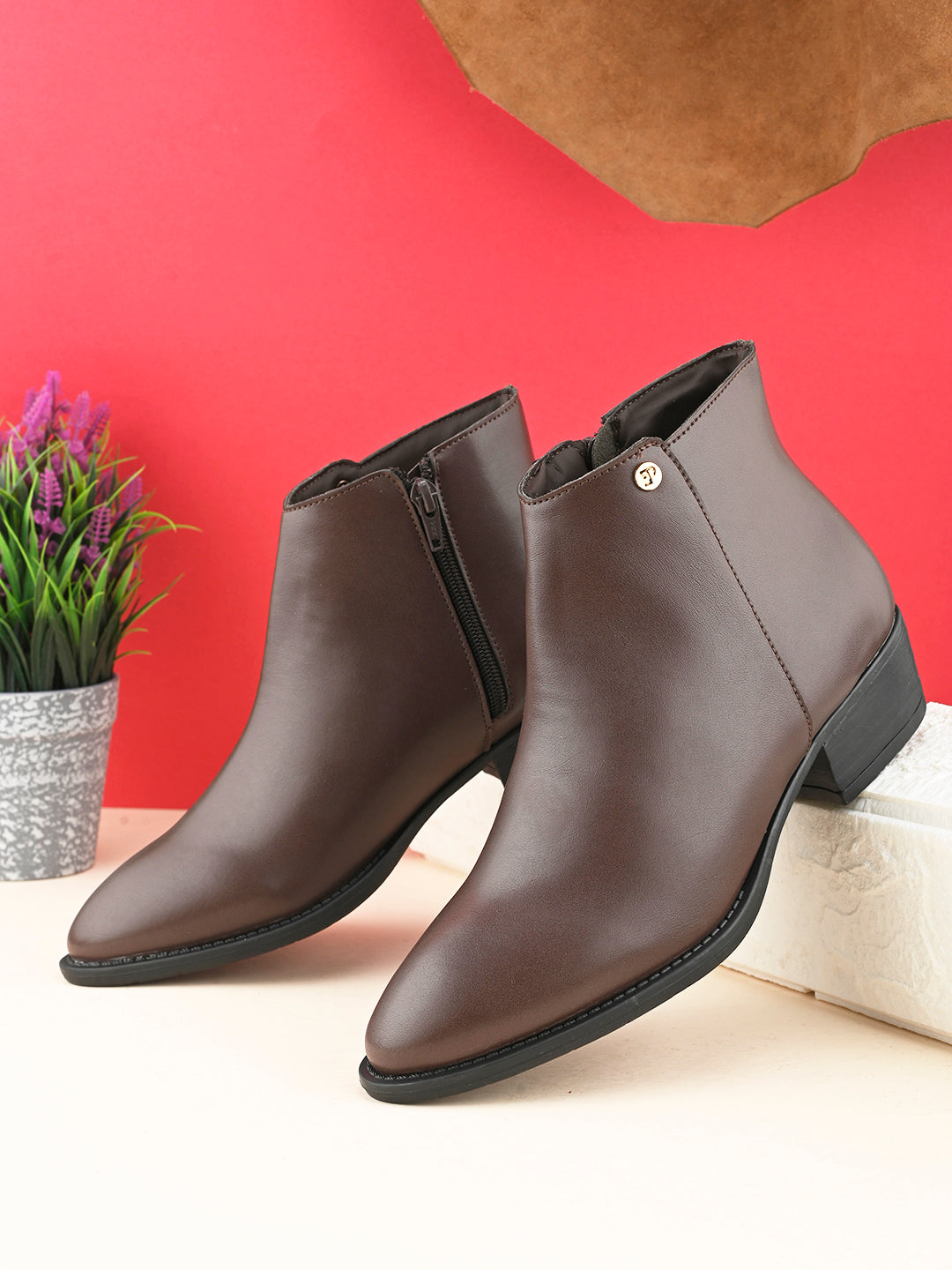 Brown leather ankle boots with a pointed toe, side zipper, and low block heel.