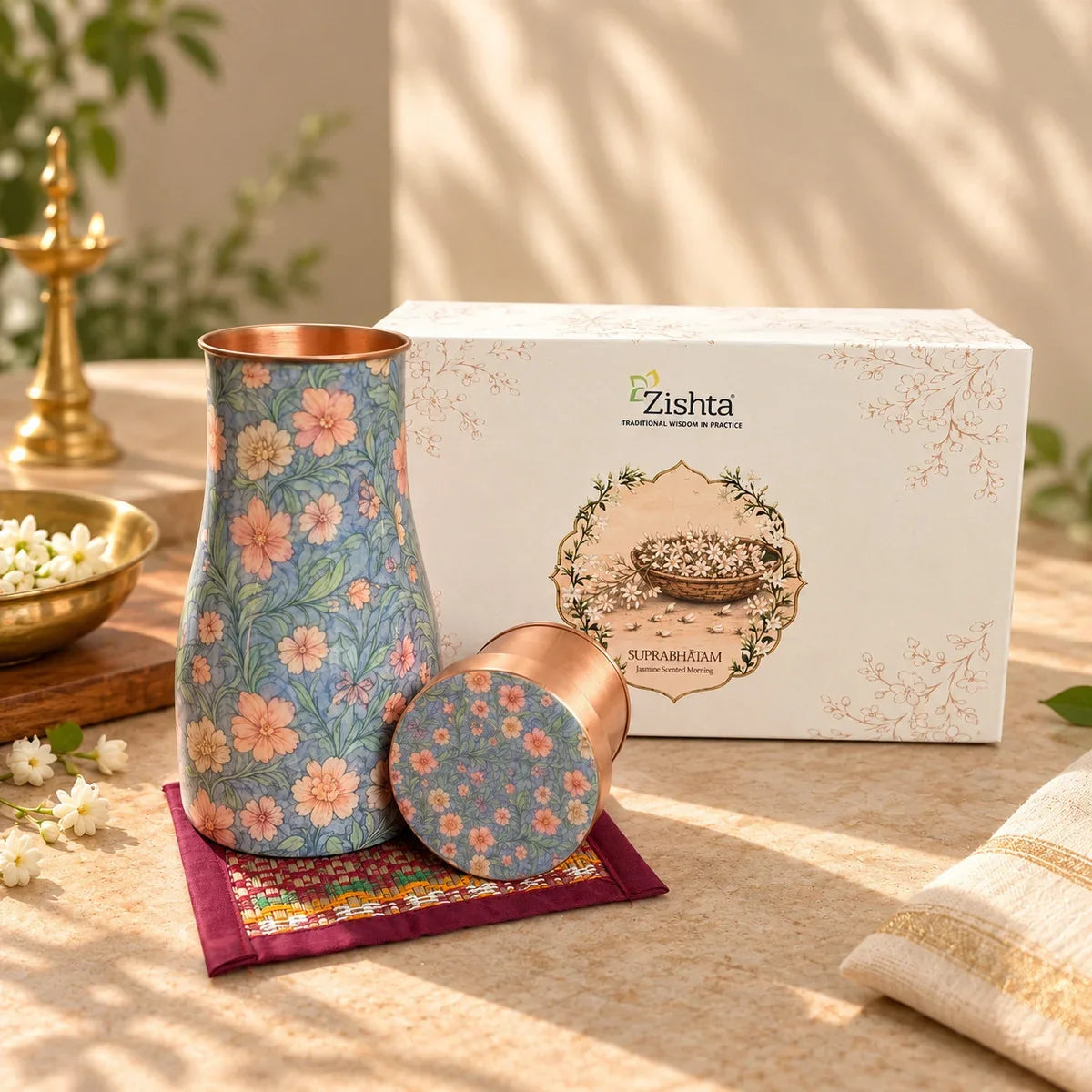 Copper carafe with blue and peach floral enamel design and matching tumbler lid, a Diwali corporate gift set. Zishta Diwali Corporate Gifting.
