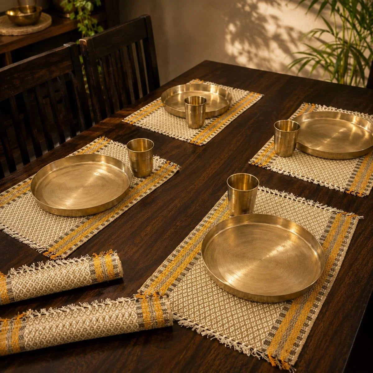 Madur table mat set badami styled with kansa plates for dining. Zishta Dining Table Decor.