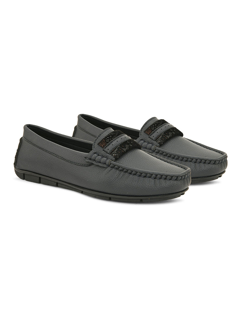 A single dark gray leather sleek loafer for women with a textured sole and decorative strap across the front.