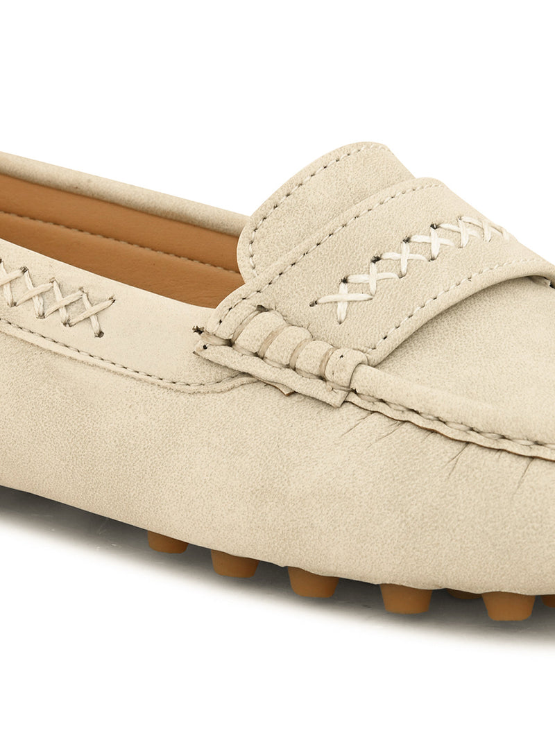 Beige suede driving loafer with stitched details, cross-stitched vamp band, and studded rubber sole.