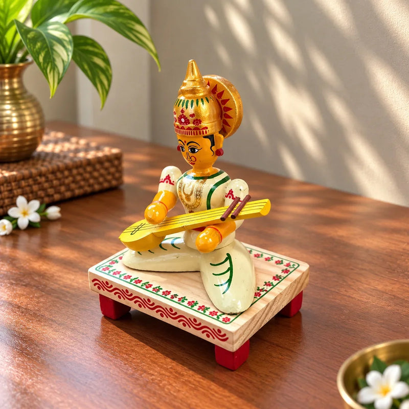 Close-up of wooden Saraswati Devi doll with veena and gold crown detail. Zishta Traditional Dolls & Toys