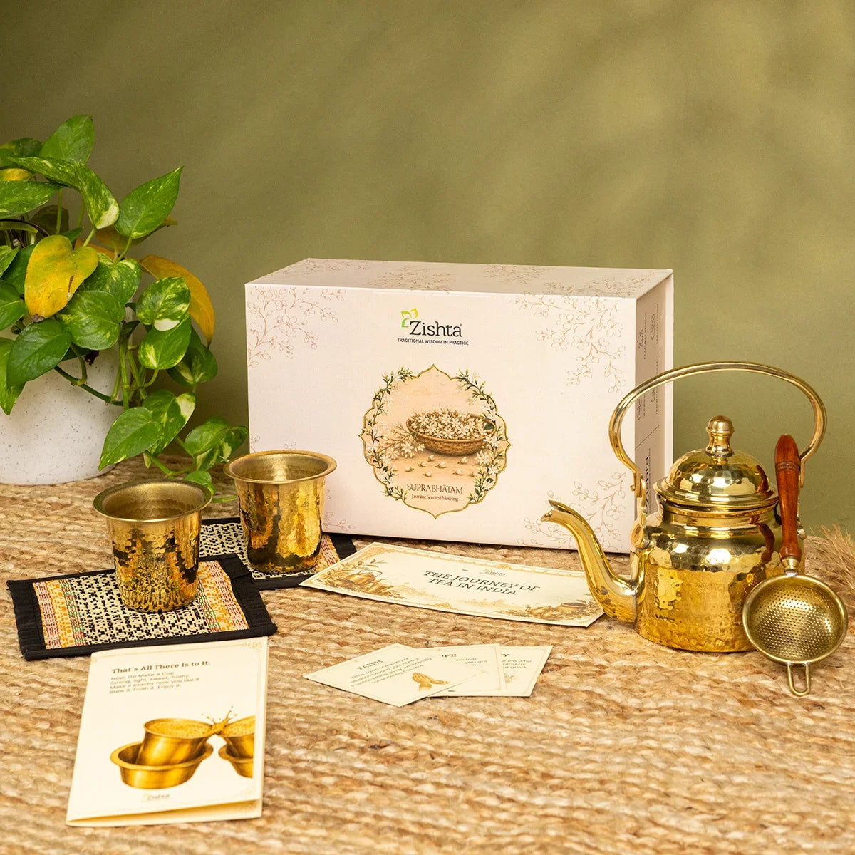 Handcrafted brass tea set with kettle, strainer and two hammered tumblers on coasters, a Zishta Diwali corporate gift for tea lovers.